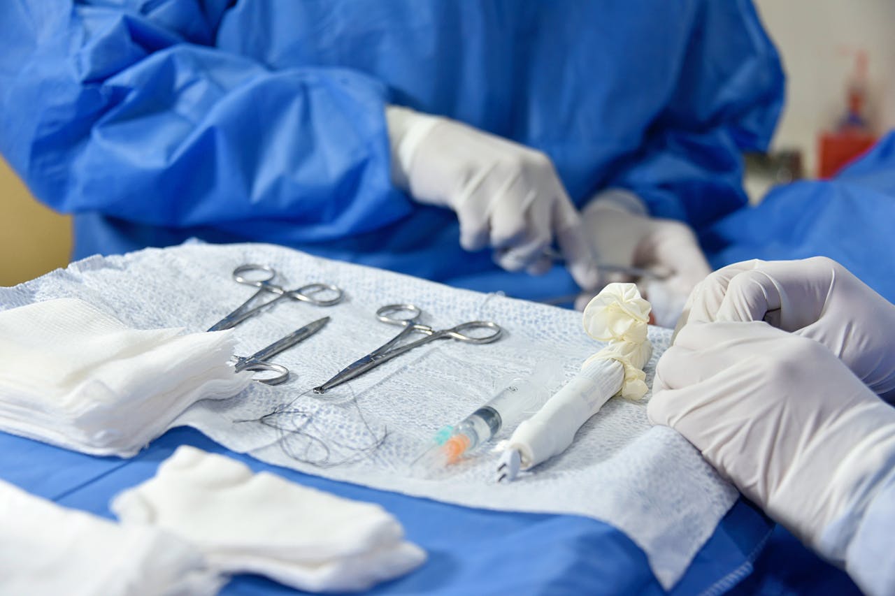 about-us Detailed view of surgical instruments and hands in blue scrubs performing surgery.
